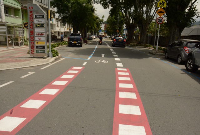 La señalización de franja roja y blanca alerta a los ciclistas y conductores el cruce entre la cliclorruta y vía.