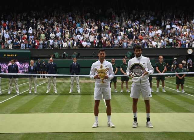 Novak Djokovic (L) de Serbia posa para una foto con el trofeo después de ganar la final masculina contra Matteo Berrettini (R) de Italia en el Campeonato de Wimbledon
