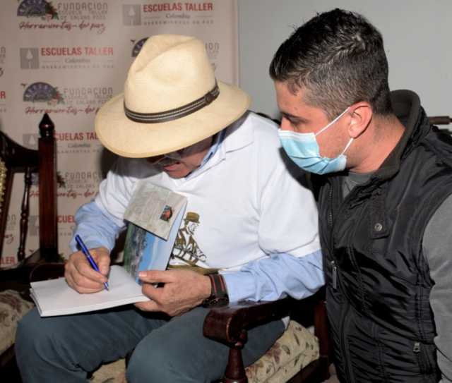 Fernando Macías firma el libro a un asistente a la presentación en Salamina.
