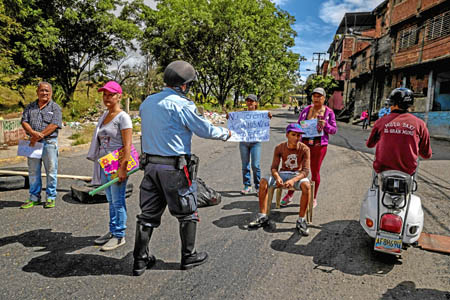 Un policía habla con un grupo de ciudadanos que participa en una manifestación en Caracas