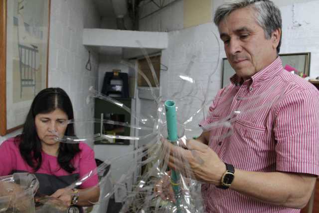 Belsy se gastó seis tijeras y varios bisturís cortando las botellas del árbol. José Fernando Quintero muestra una pieza del árbo