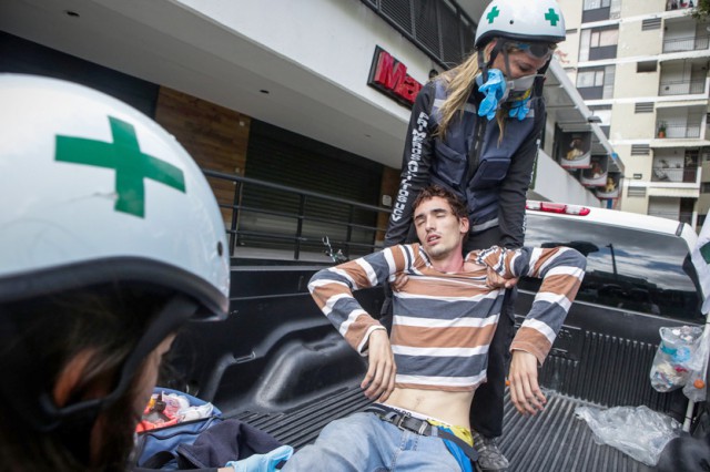 Un manifestante herido es atendido por personal de emergencia, durante los bloqueos en rechazo a las elecciones de la Asamblea N