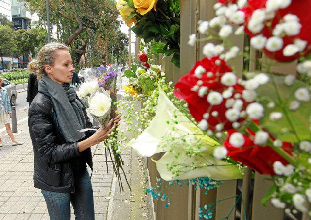 Una mujer deja flores en honor a la francesa Julie Huynh y las colombianas Ana María Gutiérrez y Lady Paola Jaimes.