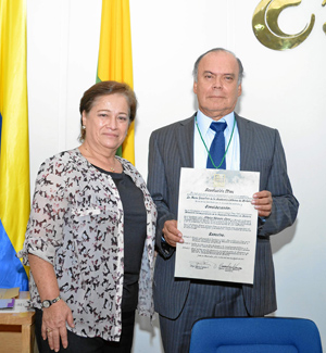 María Cristina Arango Mejía entregó el reconocimiento a Albeiro Valencia Llano, por su nombramiento como miembro correspondiente