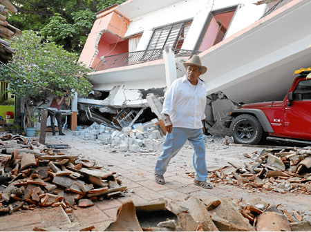 Un hombre camina junto a una vivienda destruida en el municipio de Juchitán, Oaxaca (México). 
