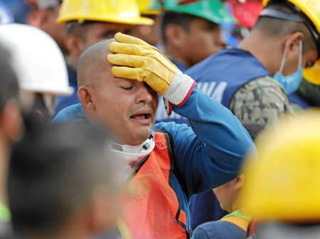 Brigadistas mexicanos y japoneses que trabajan en el rescate de personas en el edificio de la colonia Educacion se muestran tris