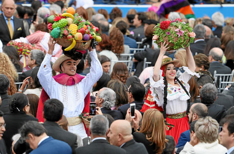 Dos bailarines vestidos con trajes típicos del folclor colombiano desfilan entre los invitados. 
