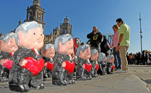 Seguidores de López Obrador observan muñecos que representan al mandatario, en la plaza del Zócalo, en Ciudad de México. 