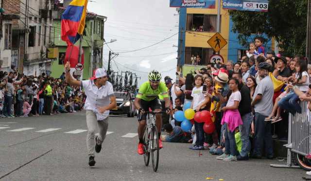 Un hombre saltó a la calle para recibir a los ciclistas con el tricolor nacional. Claro que esto no se puede hacer, por eso la P