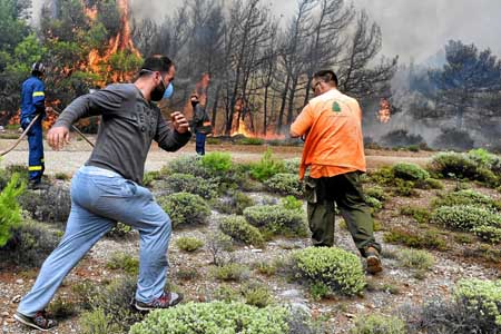 Bomberos y voluntarios luchan contra las llamas. 