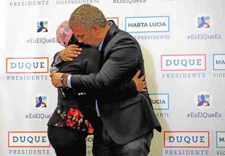 Iván Duque abraza a Vanessa García, integrante de la Corporación Rosa Blanca, una organización compuesta por mujeres que fueron 