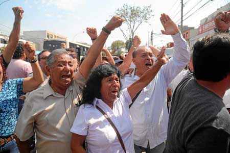 Simpatizantes de la Alianza Popular Revolucionaria Americana reaccionan afuera del hospital Casimiro Ulloa tras conocerse la mue