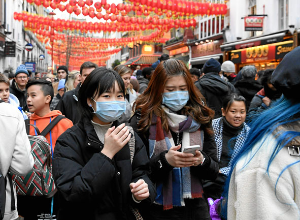 Los peatones usan máscaras durante las celebraciones del Año Nuevo Chino en Chinatown en el centro de Londres, Gran Bretaña. El 