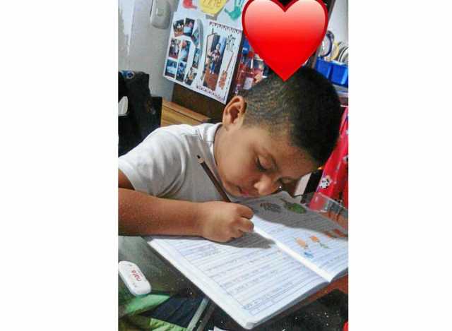 Gerónimo Rincón Bedoya, del grado quinto, de la Escuela 12 de Octubre muestra cómo hace sus tareas desde casa.