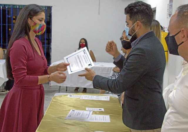 Recibe un certificado Tatiana Rojas Guzmán de manos del personero de Manizales, Fernando Arcila Castellanos