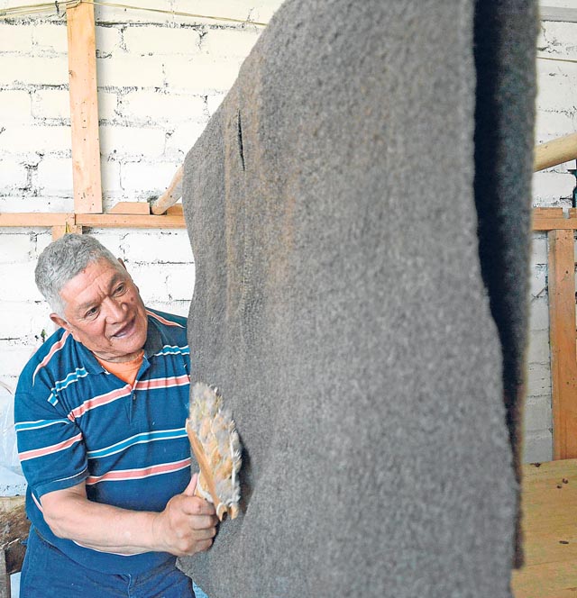 El producto final. La ruana hecha con lana de moro colombiano. Utiliza una cruceta hecha de cardas para puliirla.