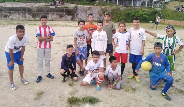 Algunos de los integrantes de la Escuela Macías Fútbol Club en la cancha en la que entrenan.