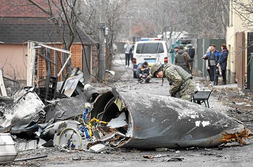 Un soldado observa los restos de un avión militar derribado en Kiev.