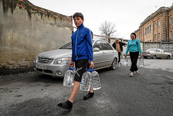 Refugiados de la autoproclamada República Popular de Donetsk recogen agua en el centro de alojamiento temporal de Novocherkassk.