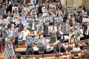 Senadores y representantes a la Cámara sostuvieron fotos de victimas del conflicto armado ayer durante la instalación del nuevo 