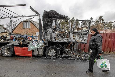 Un hombre pasa frente a un camión destruido por los bombardeos a las afueras de Kiev.