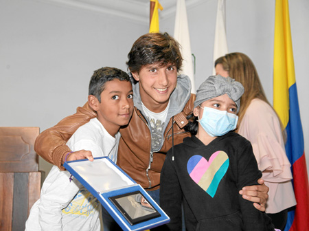 El torero Andrés Roca Rey aparece junto a los niños que le entregaron la placa con la Virgen de la Macarena, reconocimiento que 