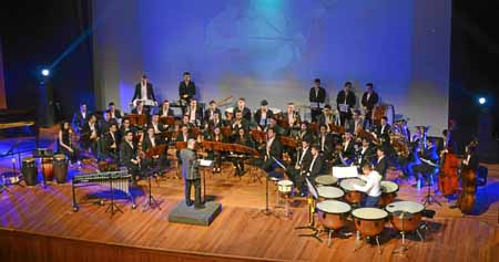 El maestro Uriel Andrés Marín Reyes, a la derecha, aparece acompañado por la Banda Sinfónica de Manizales con la dirección de Ca