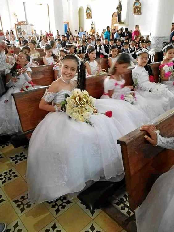 Los niños y niñas que recibieron su primera comunión desfilaron por la calle principal del municipio hasta el templo. 