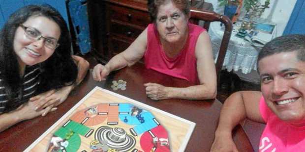Lina Marcela Zapata González, Ofelia Hurtado Marulanda y Juan Pablo Alzate Hurtado se divierten jugando parqués.