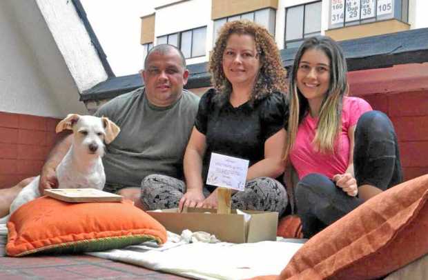 Valentina Gálvez Gómez junto con sus padres, Jhon y Viviana, y su perro Max muestran el pícnic que elaboraron en la terraza de s