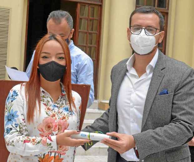 El gobernador de Caldas, Luis Carlos Velásquez, hace entrega de un reconocimiento a Katherine Rueda Ramírez, representante de Mo