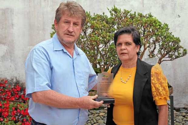 Martín Sierra Quiroz entrega un reconocimiento a Luz Eleny Valencia Gil.