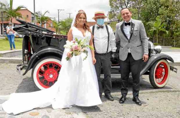 Fotos|Freddy Arango|LA PATRIA Los novios posan al lado de un antiguo Ford, modelo 1928, en compañía del conductor Henry Rivera C