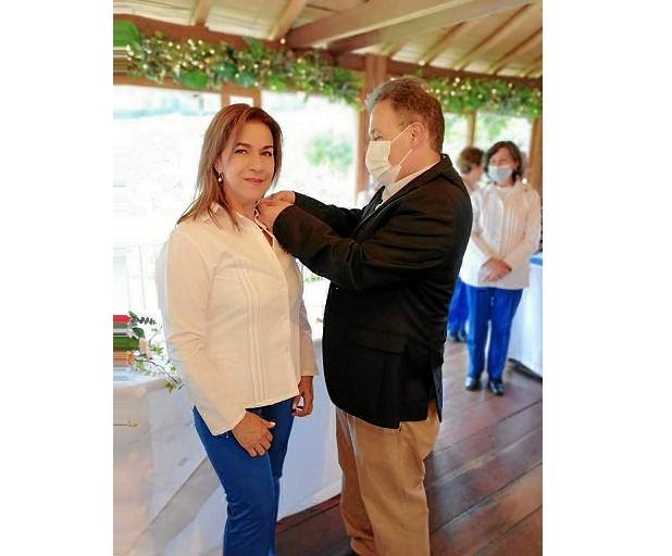 La voluntaria Martha Lucía Trejos recibe el botón de 10 años de manos del gerente de Avidanti, Carlos Hernán Estrada.