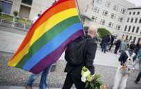 En la Puerta de Brandeburgo, en Berlín, Alemania, un hombre lleva la bandera de arcoíris, que simboliza la paz, la tolerancia y la diversidad en memoria de las víctimas del ataque.