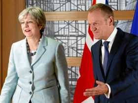 El presidente del Consejo Europeo, Donald Tusk, le muestra la salida de su despacho a la primera ministra británica, Theresa May