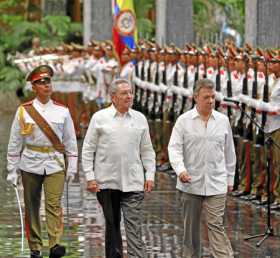 El presidente de Cuba, Raúl Castro y el presidente de Colombia, Juan Manuel Santos, pasan revista a las tropas formadas para la 