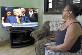 Una mujer observa el discurso del presidente de EE.UU., Donald Trump, en su vivienda en La Habana (Cuba), en el que anunció camb