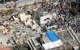 Vista aérea muestra a cientos de personas, entre afectados y rescatistas, durante labores de rescate en medio de edificios colap