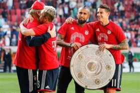 James posa con el trofeo de campeón junto al chileno Arturo Vidal.