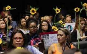 Un grupo de mujeres con girasoles en sus manos participan en la sesión de homenaje que la Cámara de Diputados de Brasil rindió e