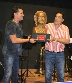 Carlos Vives recibe el busto que moldeó José Tobías Hinojosa. 