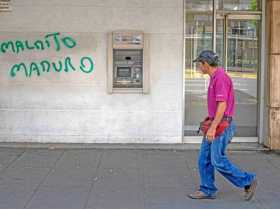 Foto | EFE | LA PATRIA Un hombre camina frente a un cajero automático fuera de servicio con una pintada contra el presidente Nic