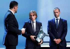 El futbolista croata del Real Madrid Luka Modric (c) recibe el trofeo al mejor jugador de la última temporada de manos del presi