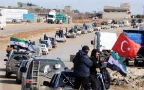 Miembros del Ejército Libre Sirio circulan junto a tropas turcas en la ciudad sitia de Azez, en la zona siria de Afrín (Siria).
