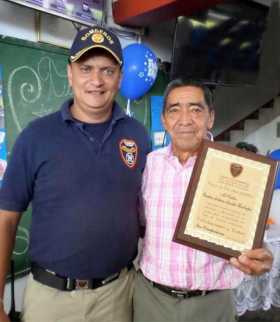 El cabo Carlos Arturo Acosta muestra la placa que recibió en reconocimiento a 23 años de trabajo en el Cuerpo de Bomberos de Ans