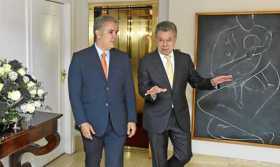 Iván Duque y Juan Manuel Santos caminan por la Casa de Nariño.