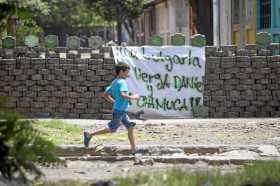 Un niño corre frente a una barricada, el viernes, durante el día 73 de protestas contra el gobierno de Daniel Ortega, en un barr