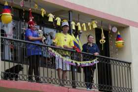 Los hermanos Amanda, Humberto y Gilma Valencia Alzate en el balcón de su casa. Ni los perros Odi, con camiseta de la Selección, 