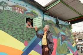 El tendero Gilberto Gutiérrez dialoga con su vecino Gersaín Giraldo sobre las nuevas fachadas de las viviendas del barrio Villah